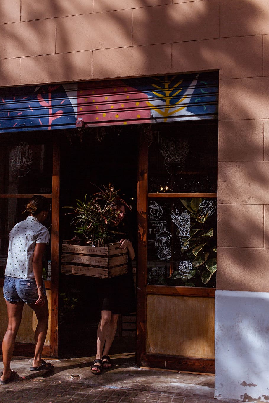 woman standing beside door, sunlight, person, shop, store, crate