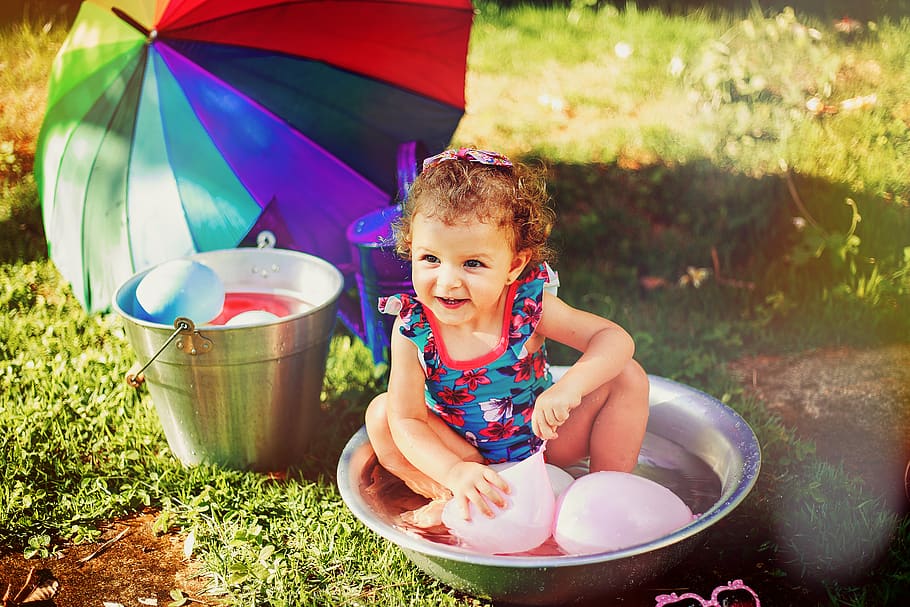 Smiling Girl Sitting on Gray Stainless Steel Basin Playing With Pink Balloons HD wallpaper