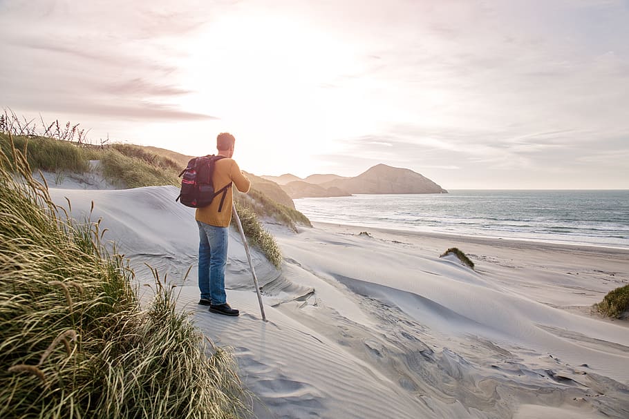 Man Stands on White Sand Beach, backpack, daylight, dunes, early morning HD wallpaper