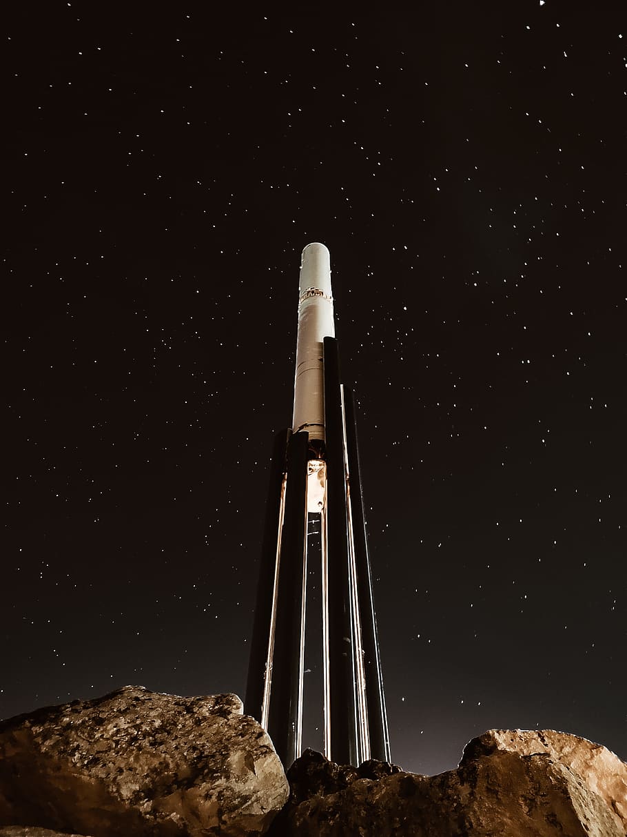 white and black tower near stones, rocket, night, sky, star, light HD wallpaper