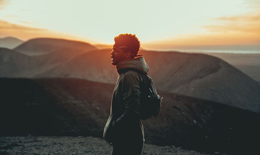 standing man beside mountain range during daytime, one person HD wallpaper