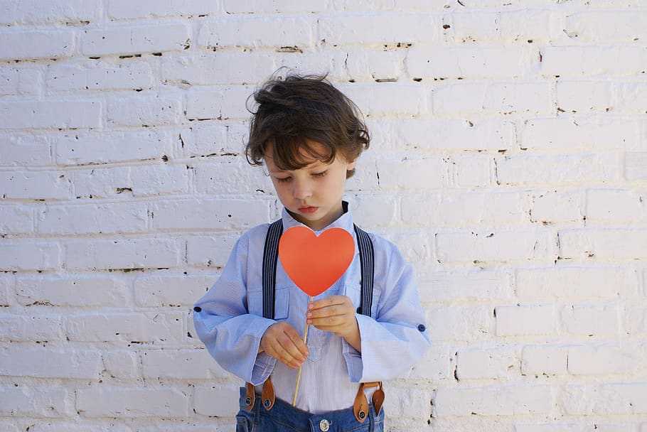 Photo of Boy Holding Heart-shape Paper on Stick, brick wall, child HD wallpaper
