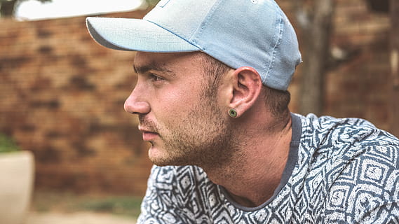 Selective focus photography of person wearing LA Dodgers cap