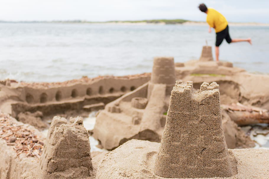 selective focus photography of sand castle near man standing on seashore, HD wallpaper