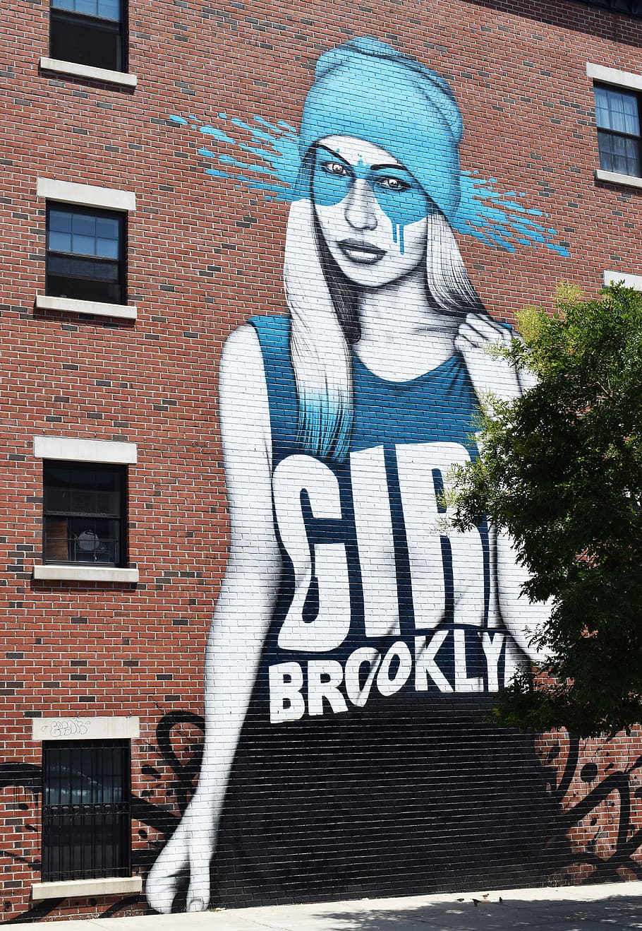 A graffiti painting of a tall girl with a tank top that says 