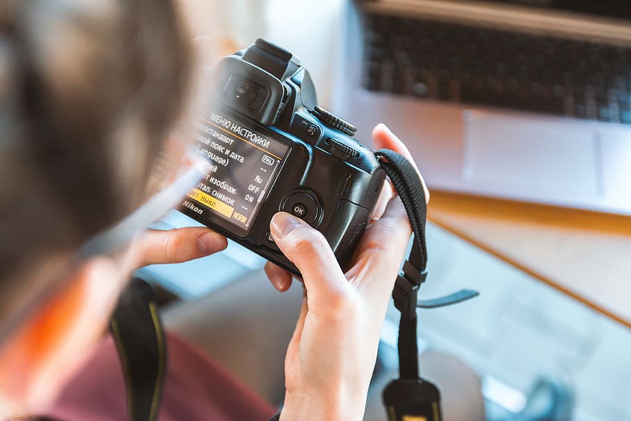 Photographer working on his DSLR camera in the cafe, one person HD wallpaper