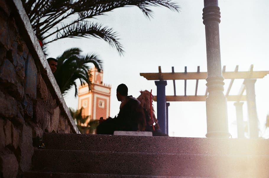 photography of silhouette of man sitting on park bench near concrete stairs HD wallpaper