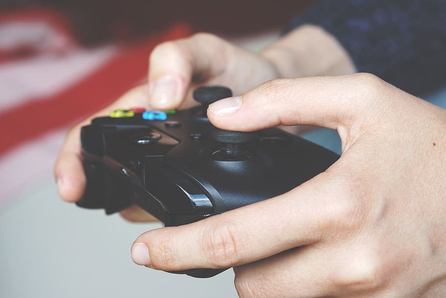 Man Holding Black Game Controller, close-up, electronics, fingers HD wallpaper