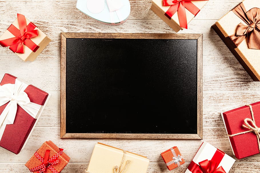 Chalkboard With Brown Wooden Frame Surrounded by Red Gift Boxes