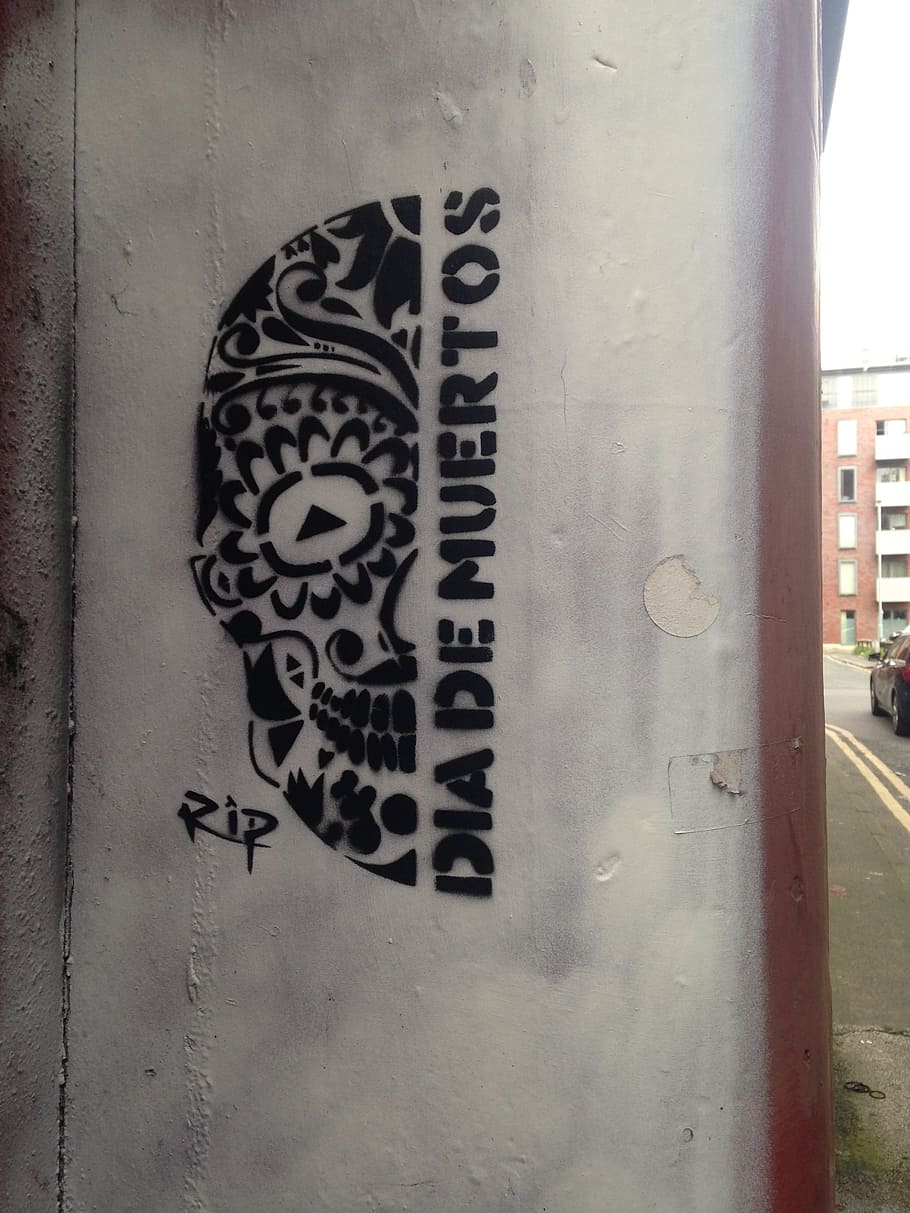 Stencilled graffiti, Dia De Muertos design, on a wall in Manchester's Northern Quarter.