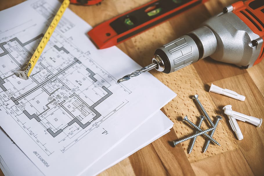 Closeup drill tool on wood background with plans for the apartment HD wallpaper