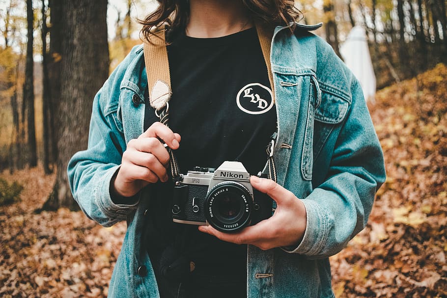 woman holding gray Nikon camera, leafe, tree, denim, vintage camera HD wallpaper