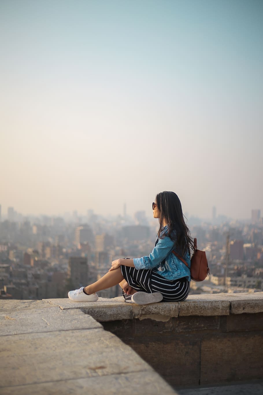 Woman Sitting on Top of Building's Edge, architecture, blur, blurred background