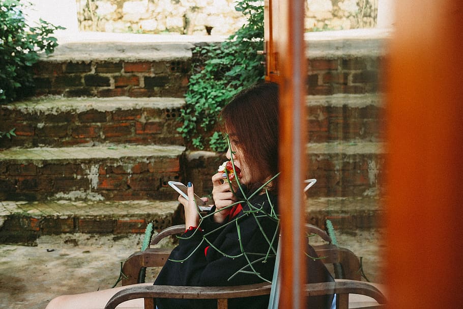 Woman Holding White Smartphone, apple, bite, cellphone, chair HD wallpaper