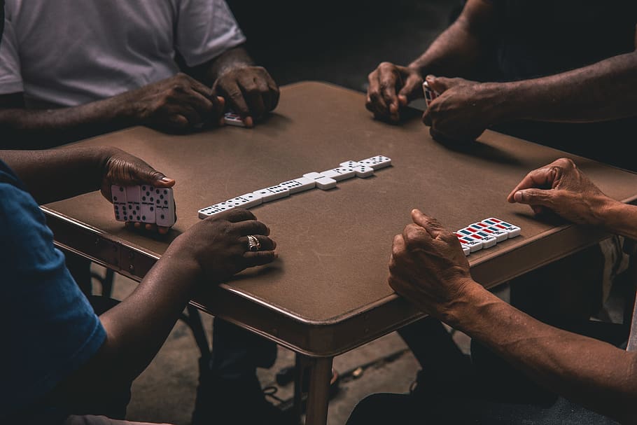 Four People Playing Dominoes, games, hands, indoors, group of people