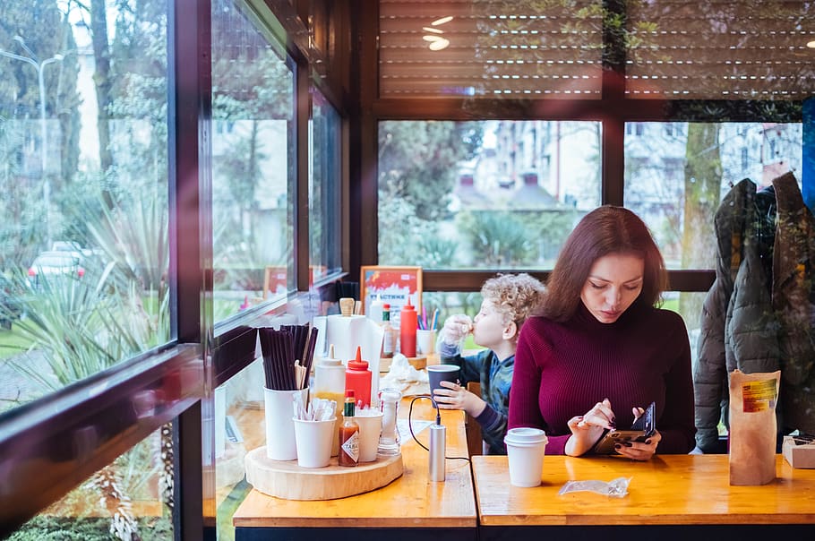 Woman Sitting Beside Table While Using Phone, child, coffee, condiments HD wallpaper