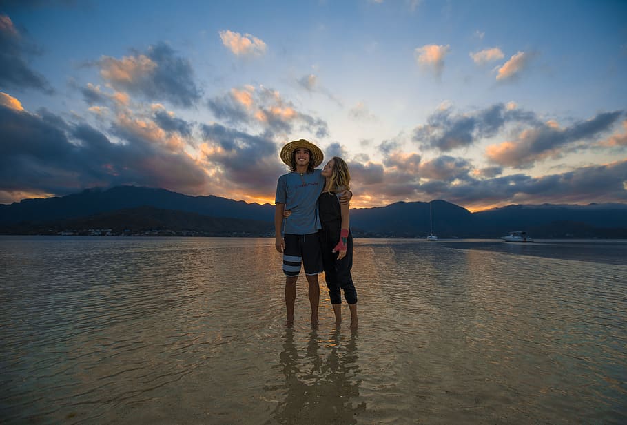 Two Person Standing on Body of Water, beach, clouds, cloudscape HD wallpaper