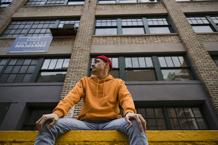 Man Sitting in Front of Brown High-rise Building, architecture HD wallpaper