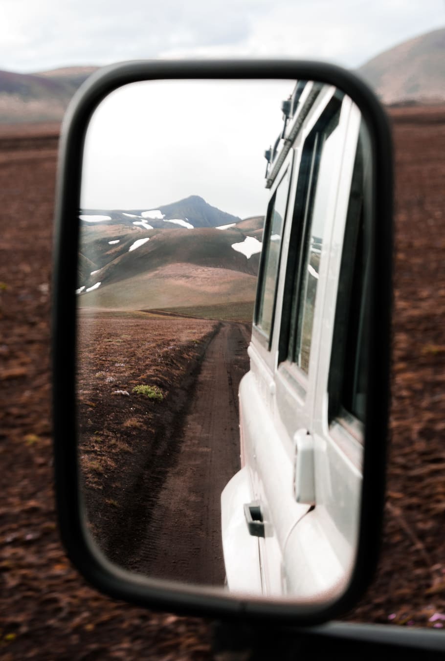 mountain range seen from vehicle wing mirror, side mirror, land rover