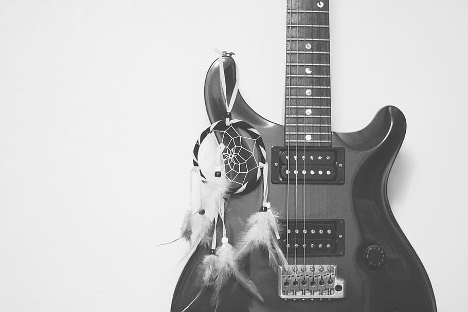 Grayscale Photography of Dreamcatcher Hanging on Electric Guitar