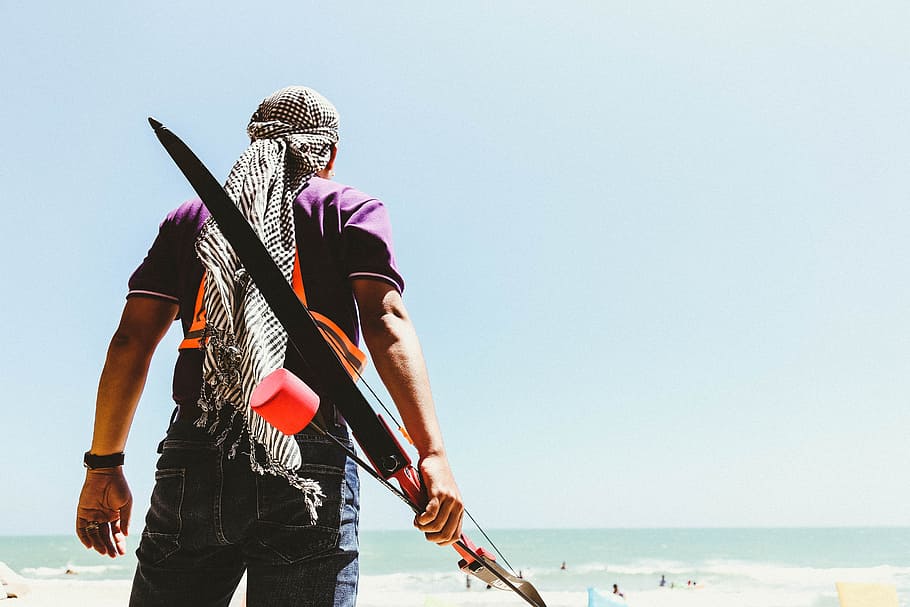 Man Holding Bow in Seashore, archery, back view, beach, bright HD wallpaper