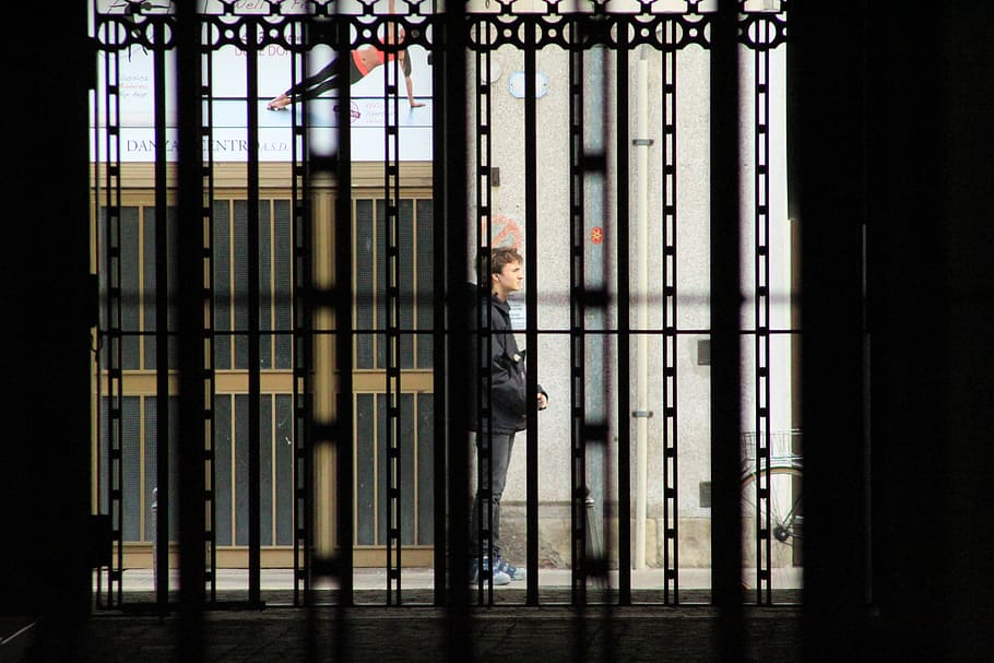 person in black jacket standing, human, gate, prison, door, window, HD wallpaper