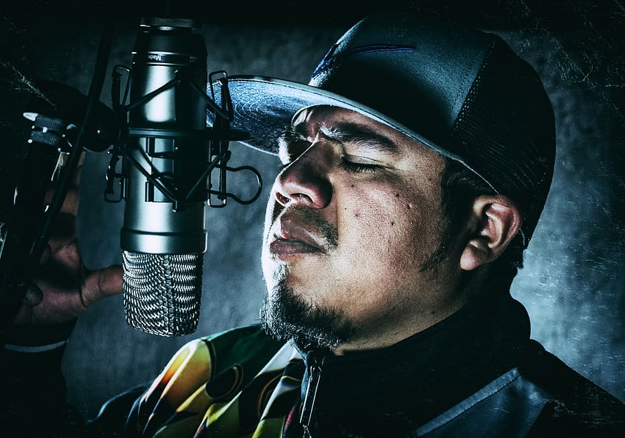 Man in Black Flat-brimmed Hat in Front of Condenser Microphone