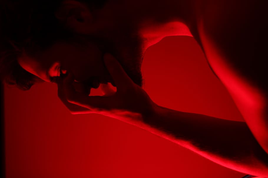 man holding him face, red, studio shot, colored background, human body part