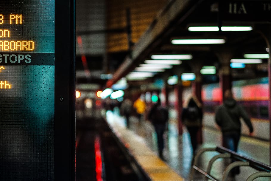 City subway platform lit with signs and commuters walking to their destination, HD wallpaper