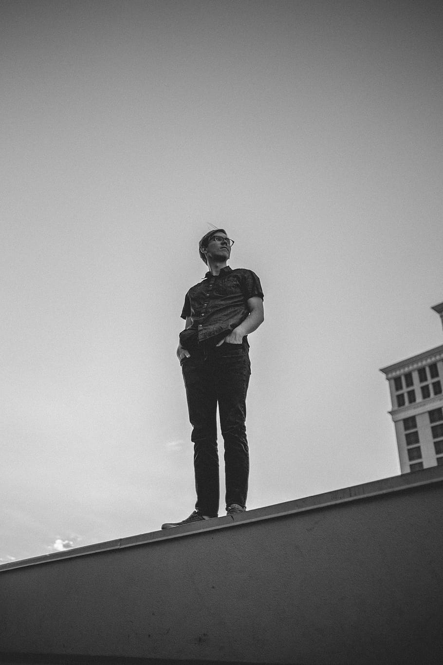 man standing on building edge, one person, sky, full length, low angle view HD wallpaper