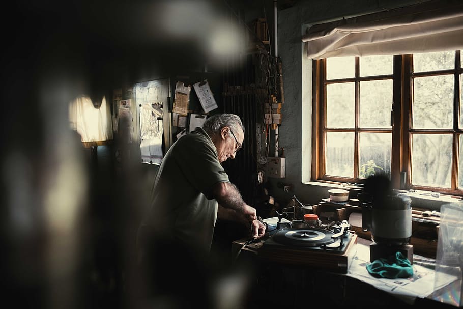 man holding handheld tool standing beside window, male, table, HD wallpaper