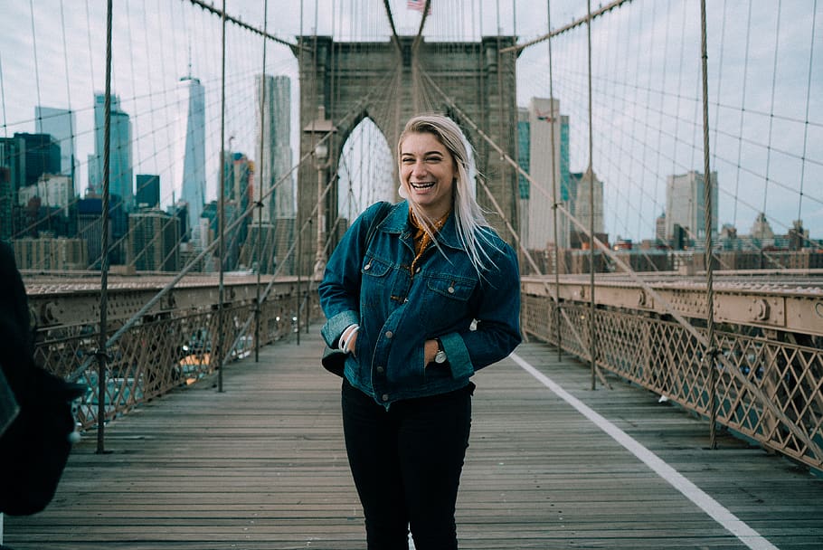standing smiling woman wearing blue denim button-up jacket at Brooklyn Bridge, HD wallpaper