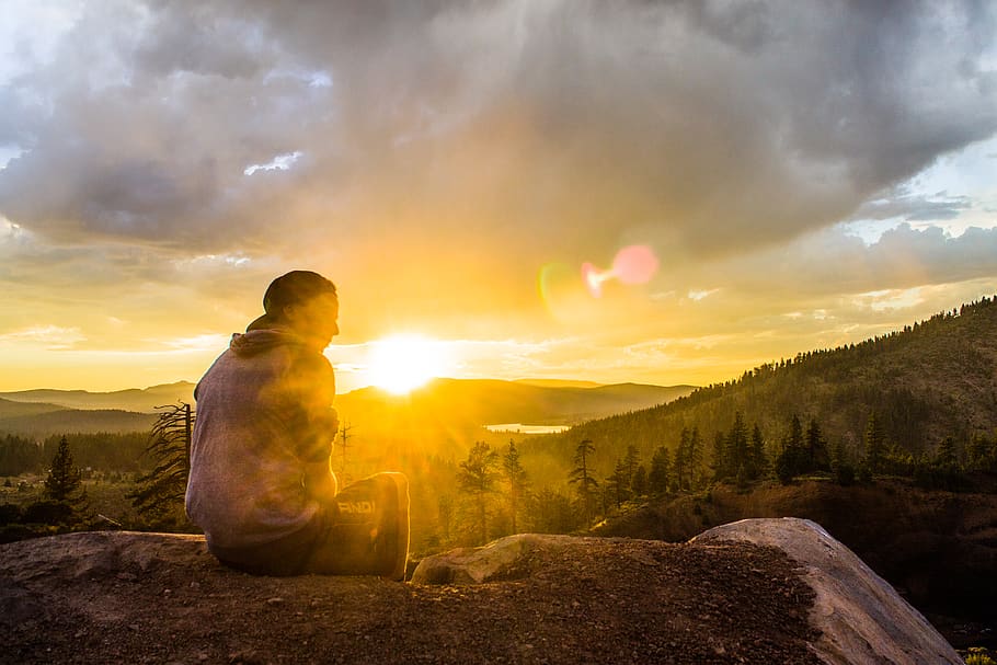 Person Sitting on Stone Facing Sunset, backlit, clouds, colors HD wallpaper