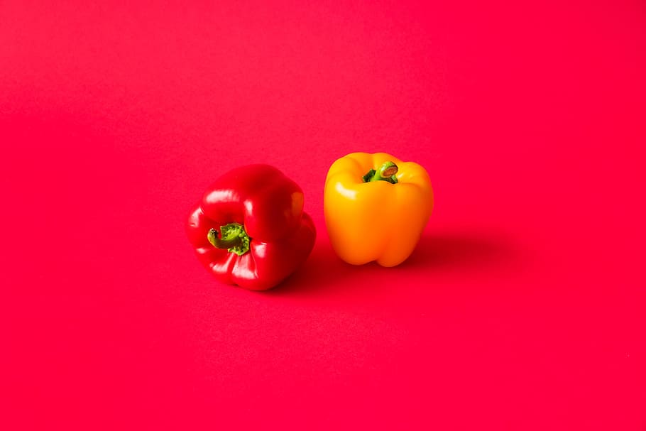 Red and Yellow Paprika Peppers on Flat Background Still Life