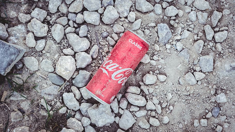 Coca Cola soda can on gray soil during daytime, solid, text, high angle view