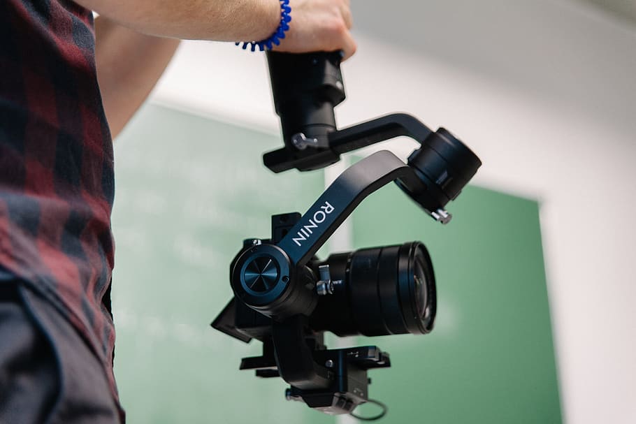 person holding Ronin camera mount, human, electronics, tripod HD wallpaper