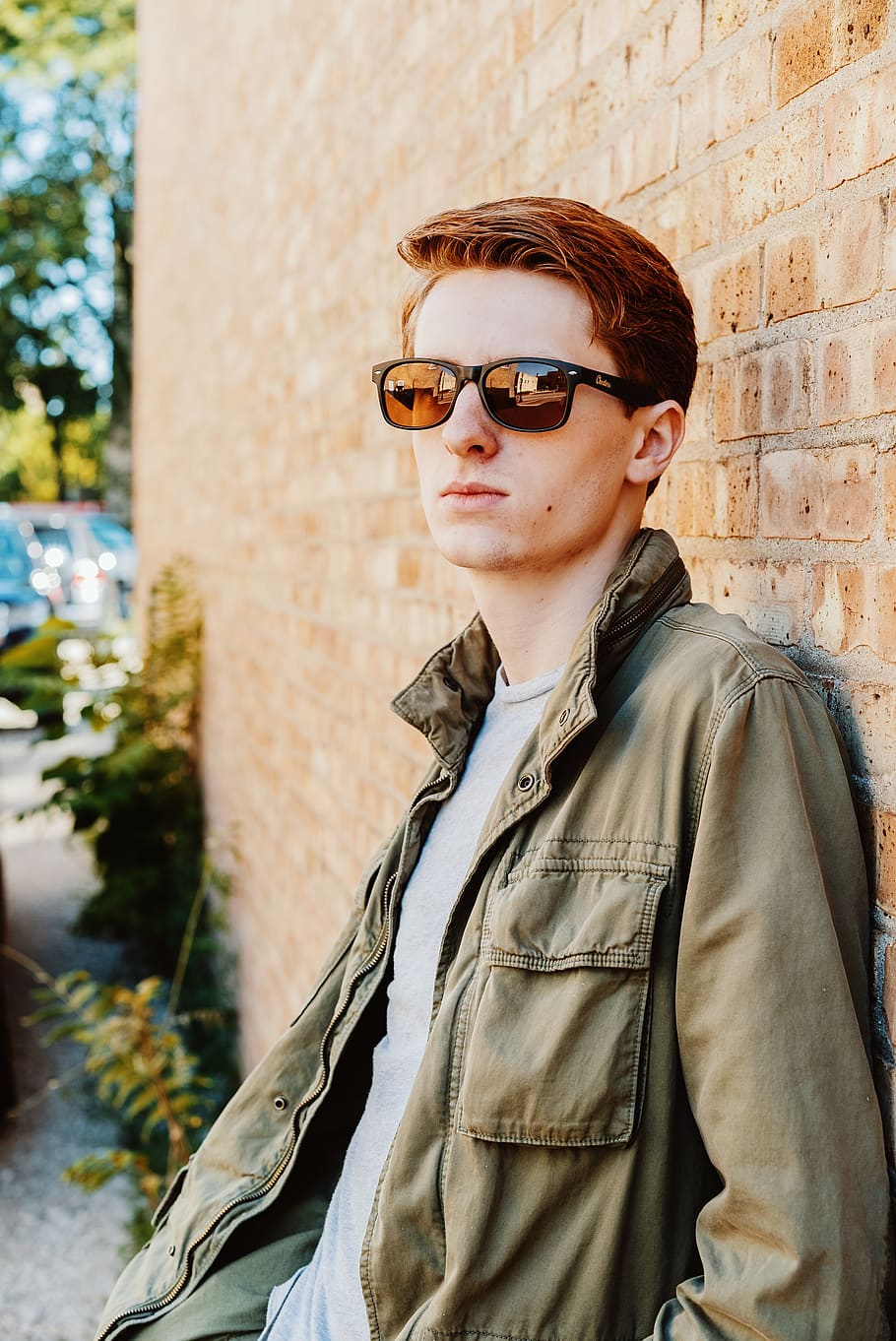 man in green jacket leaning on brown brick wall, people, human HD wallpaper
