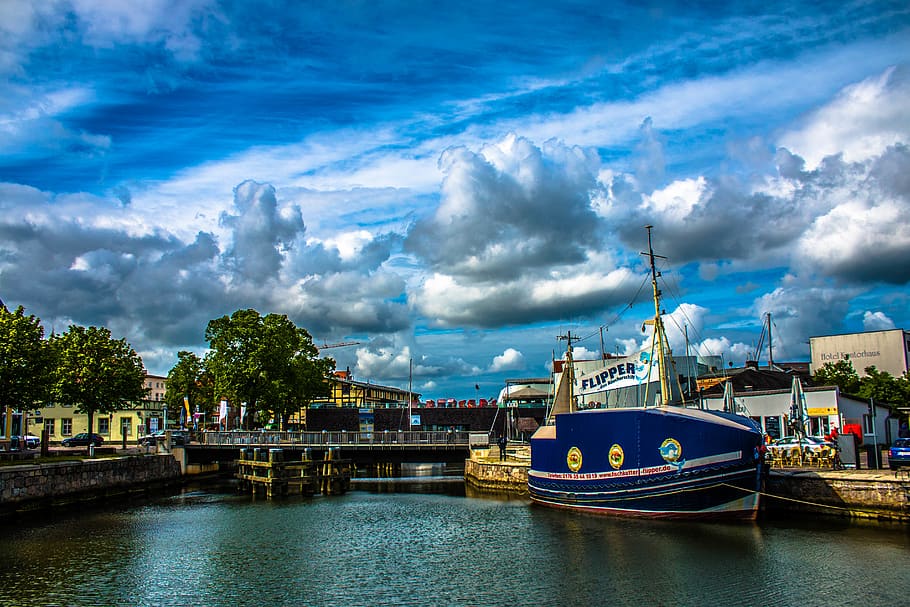 Blue and White Ship in Front of Concrete Structure, architecture HD wallpaper