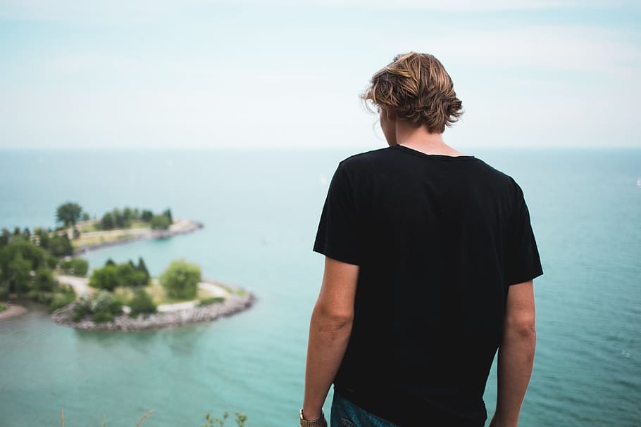 A young caucasian man looks at the ocean from the top, 20-25 year old HD wallpaper