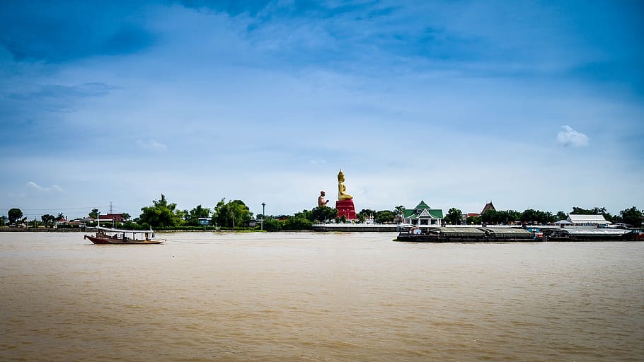 Buddha Statue in Thailand sits at river edge, buddhism, religion