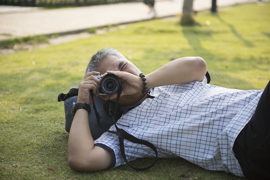 man using camera while laying down, person, human, electronics HD wallpaper