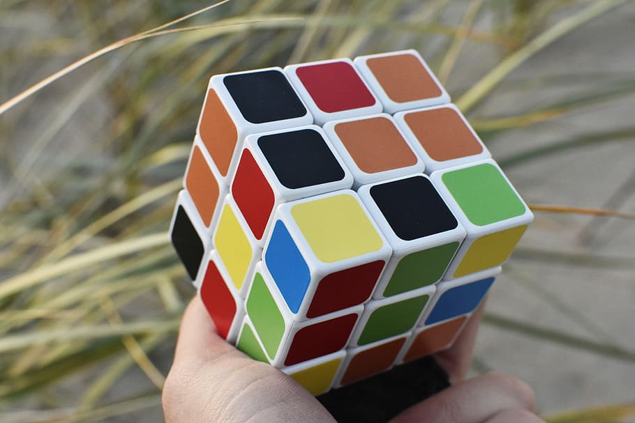 rubik cube, hand, outside, puzzle, game, colors, concentration HD wallpaper