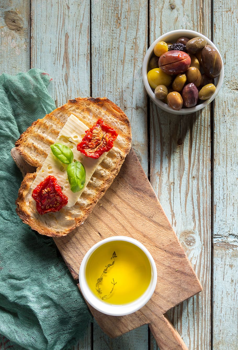 Bread With Toppings and Gray and Green Olives in Bowl, cuisine