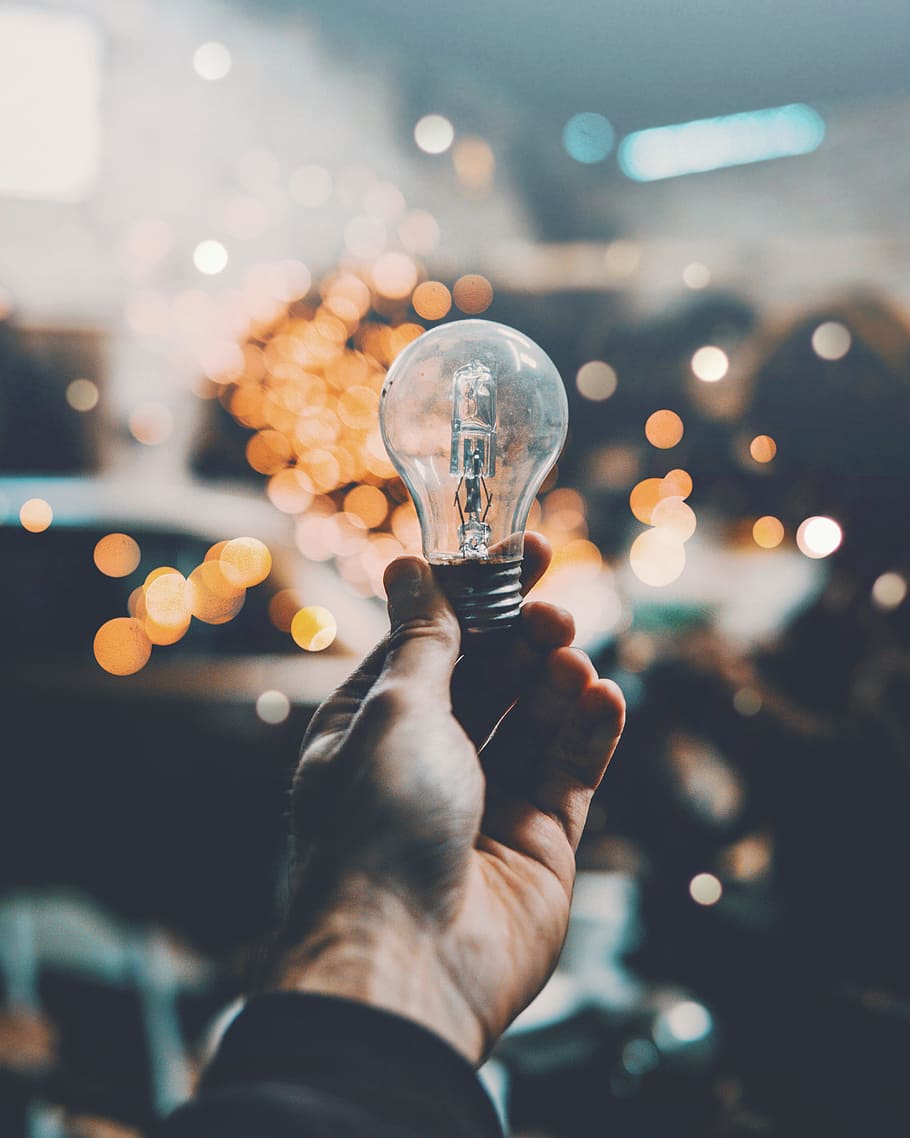 person holding light bulb, hand, bokeh, blur, glass, orange, 1.4