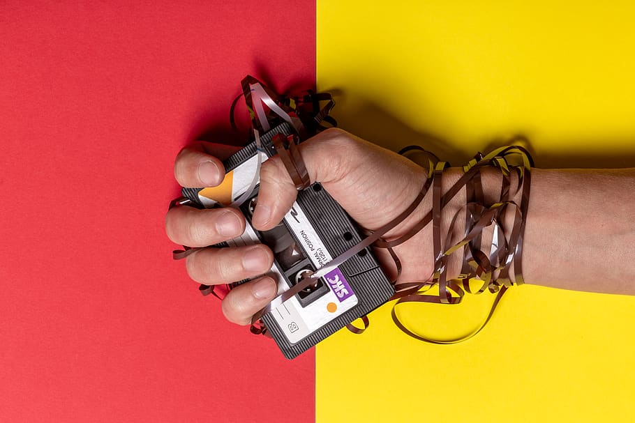 Person Holding Black Cassette Tape, hand, human hand, yellow HD wallpaper