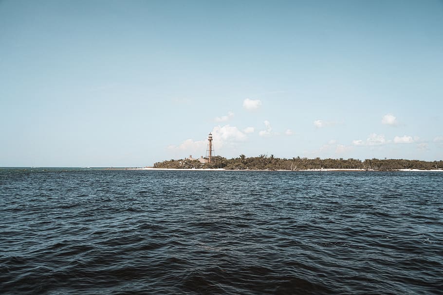 lighthouse on island under blue sky, nature, outdoors, ocean HD wallpaper