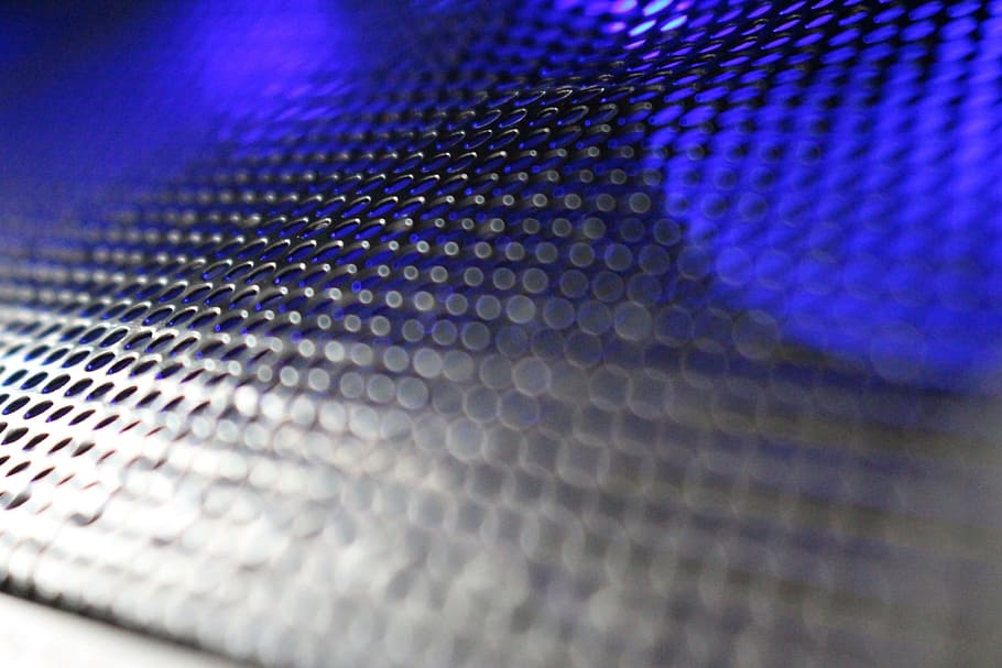 Abstract background of metallic mesh with blue and white light shining through
