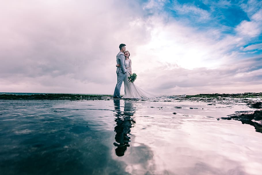 Man in Gray Dress Suit Jacket Embraces Woman Wearing Wedding Gown HD wallpaper