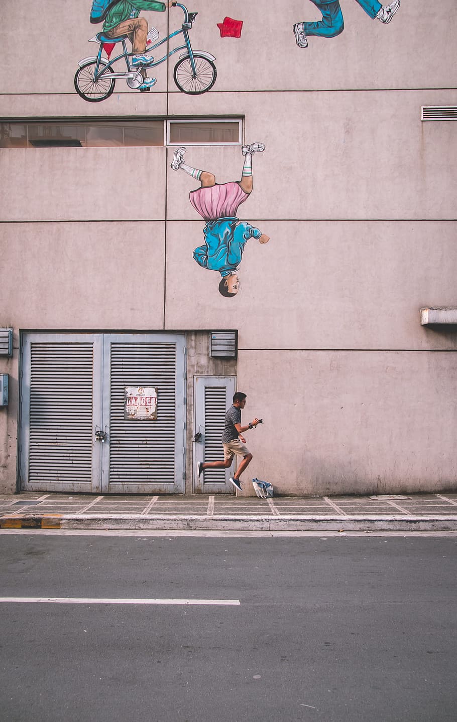 man jumping beside building during daytime, wallpaper, ios wallpaper HD wallpaper
