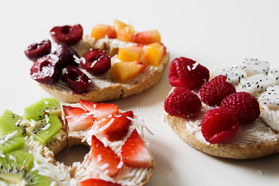 Sliced Variety of Fruits on Round Baked Bread, bagels, berries HD wallpaper